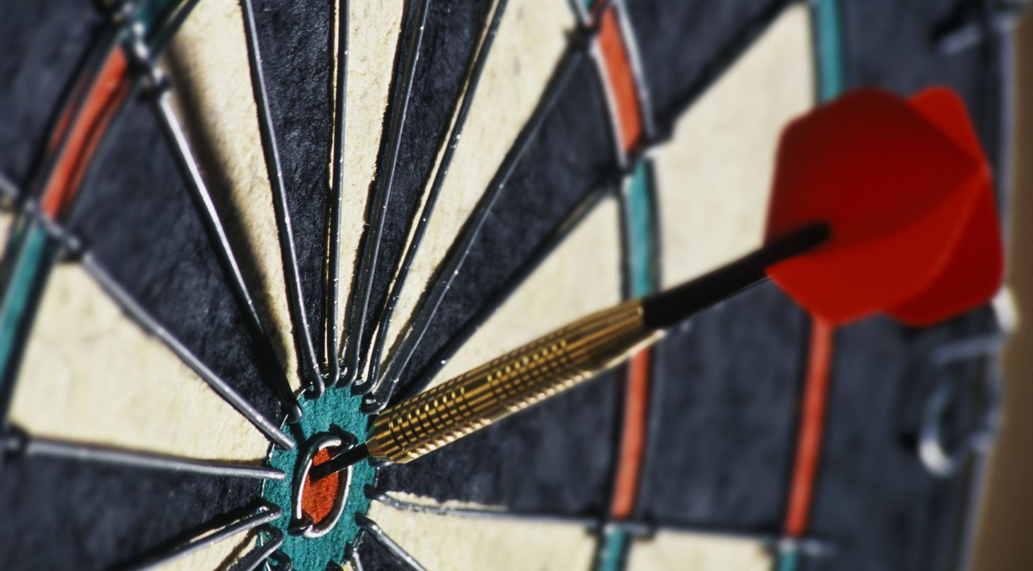 dartskive med pil i midten af målskive - udsnit af skive