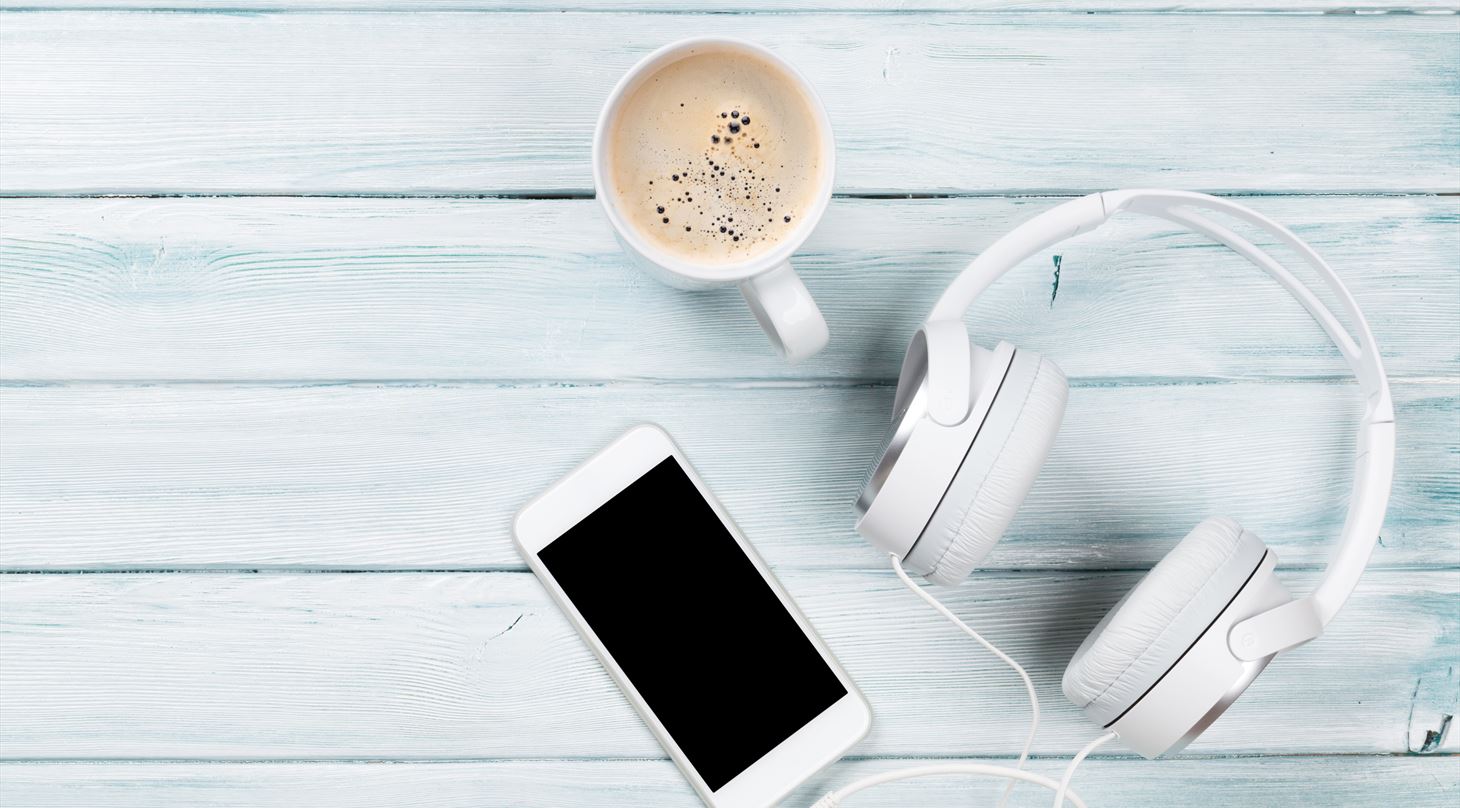 Billede af høretelefoner, varm kaffe og en mobil - Teknologisk Instituts podcast-billede
