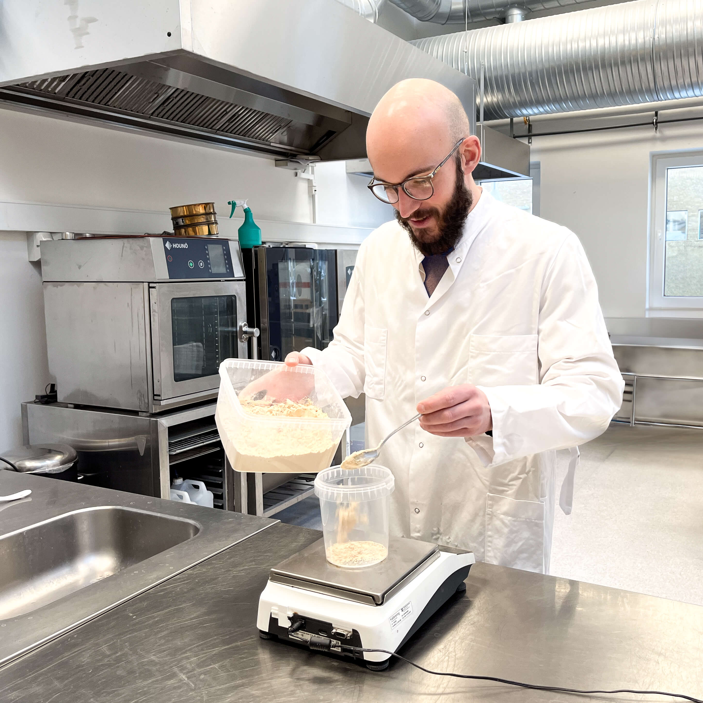 Specialist stor i udviklingskøkkenet, Foodturlab, og afmåler pulver.