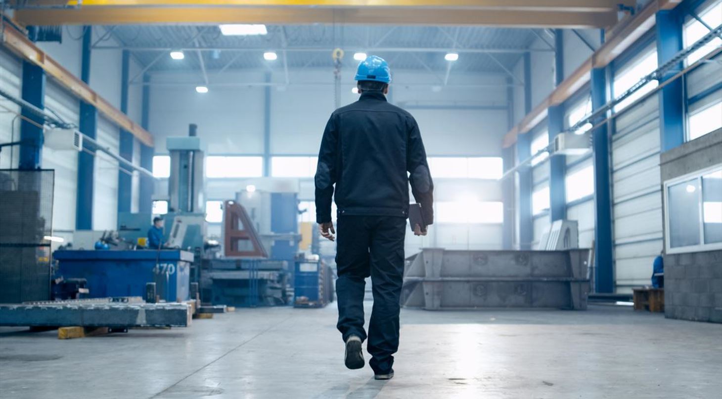 Person inspicerer produktion for at sikre god luftkvalitet i industrimiljø.